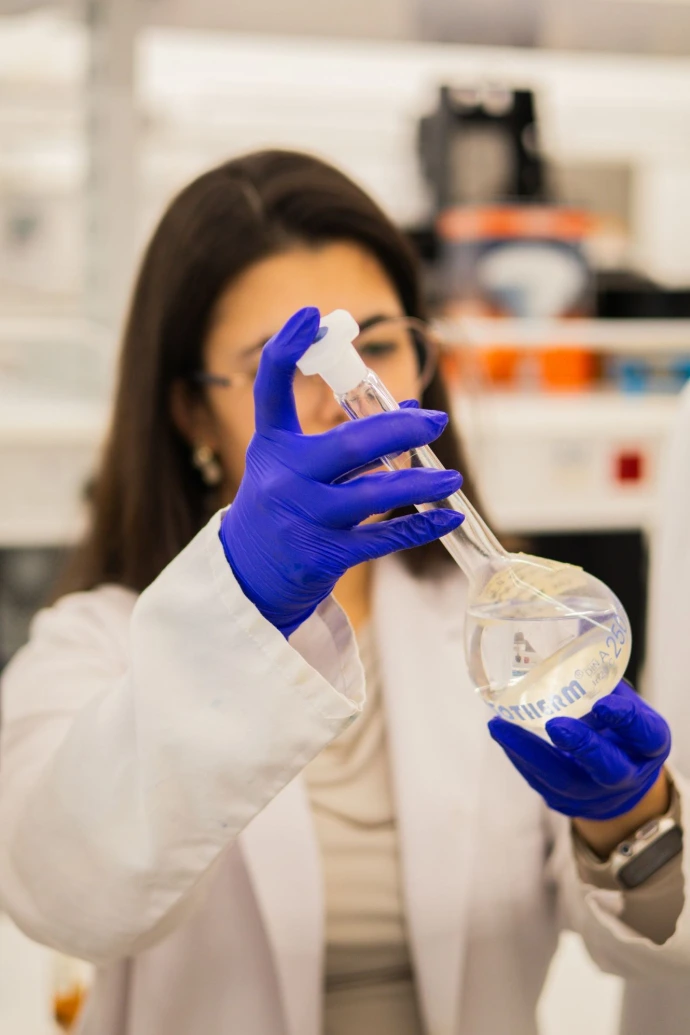 Scientist holding flask with liquid in laboratory